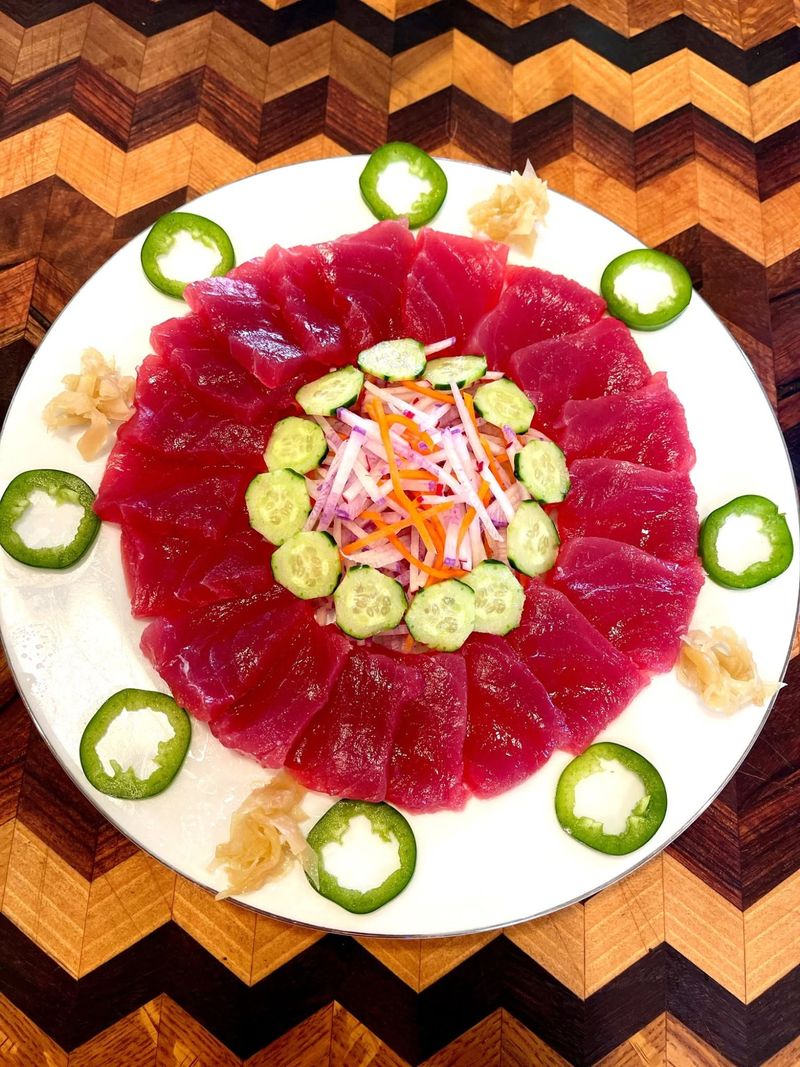 Slices of fresh ahi arranged in a ring around cucumber and radish
